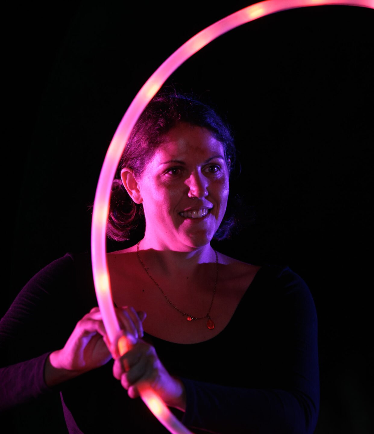 female fire performer with lighted hoop